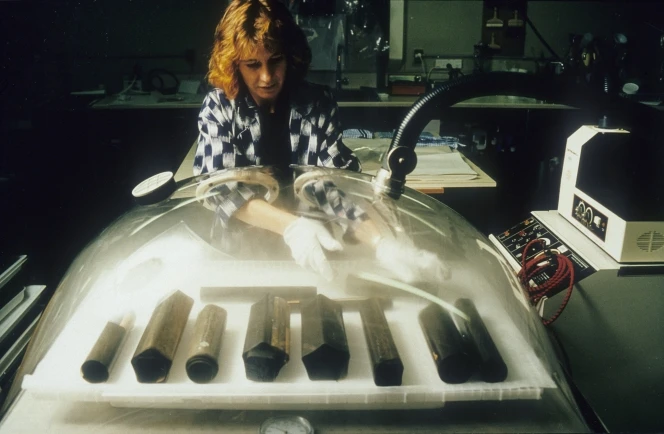 Conservator Marion Mertens placing creased rolle of film into a humidification chamber. Credit: Mark Strange, Conservation Services, ATL.