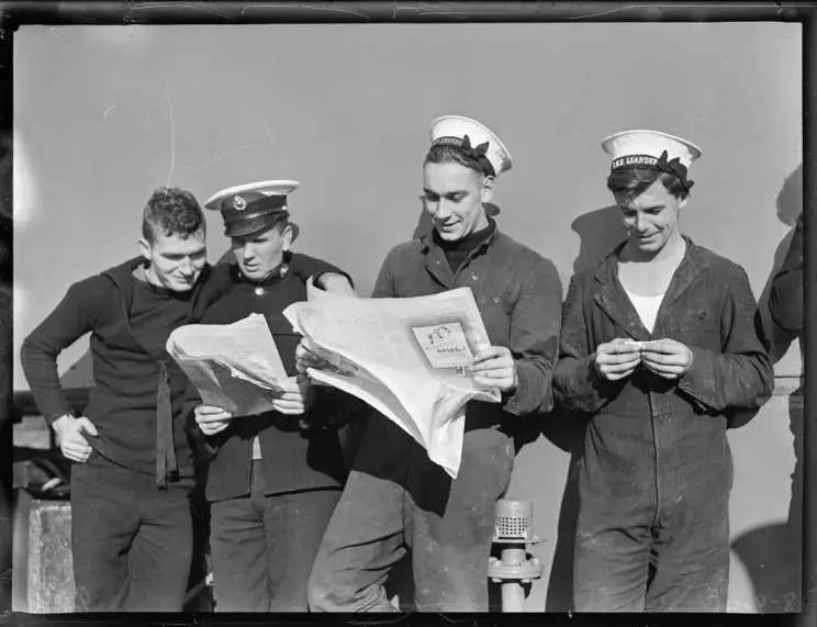 Sailors from HMS Leander, reading newspapers.