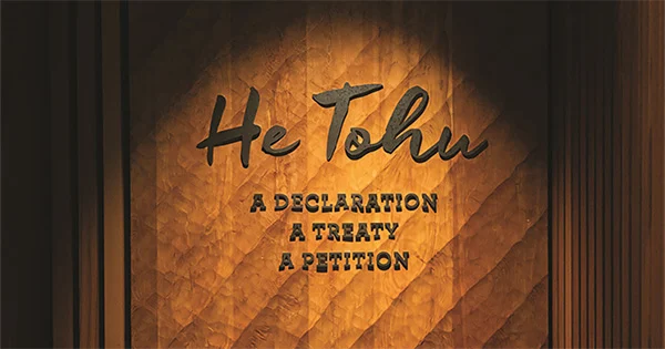 The text 'He Tohu - A Declaration, A Treaty, A Petition' spot lit on a wooden wall.