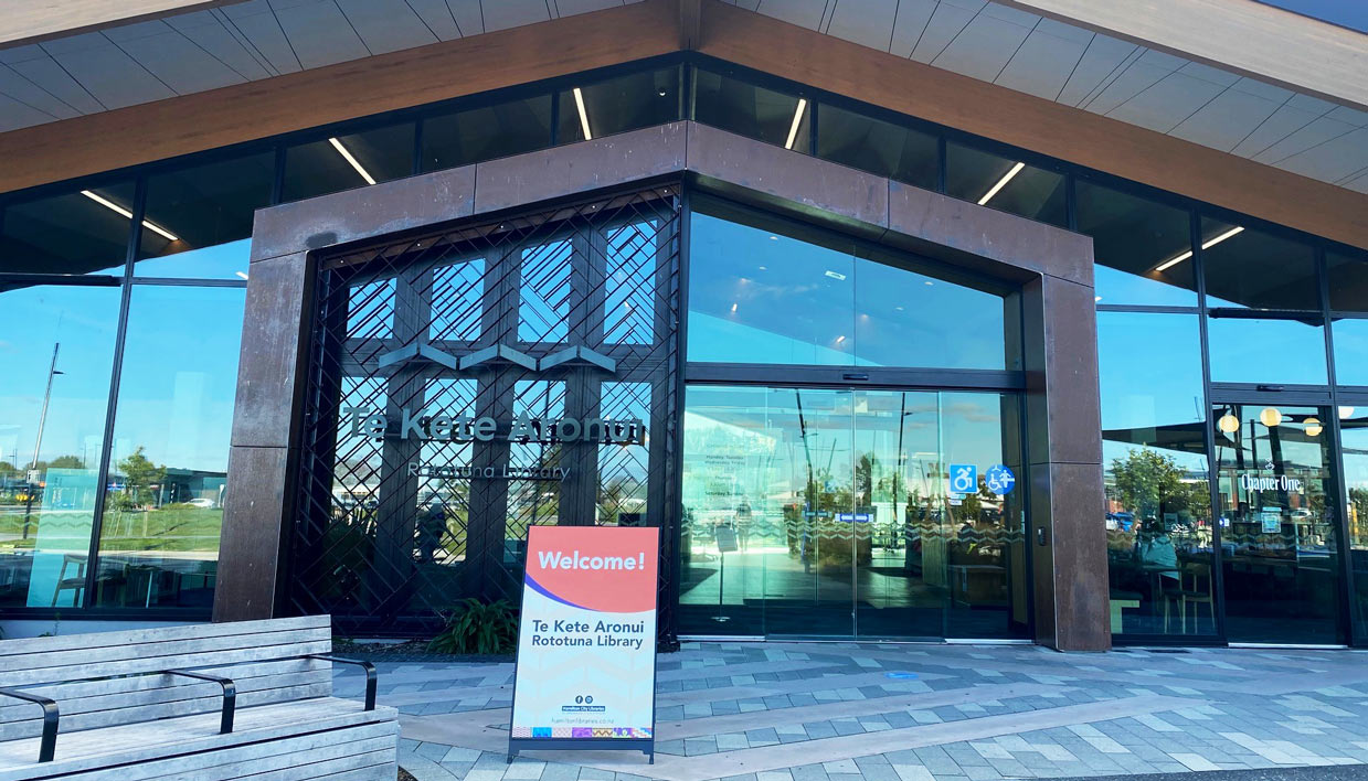 Te Kete Aronui Rototuna Library entrance with a welcome sign in front of the doors.