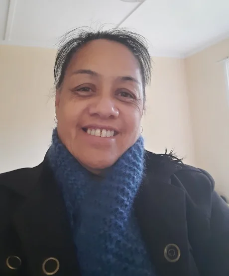 Māori woman smiling at the camera and wearing a scarf. 
