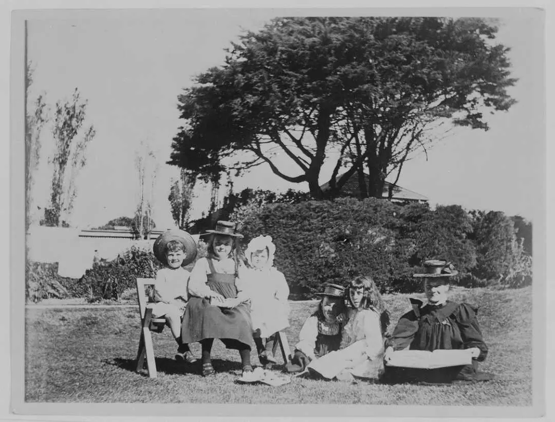 Beauchamp family children seated outside on the lawn in formal dress