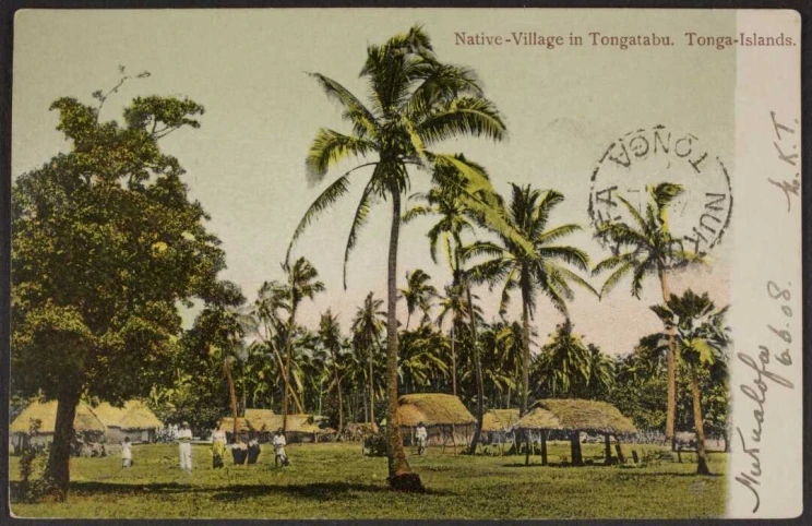 Postcard shows a coloured photograph of the huts and thatched shelters of a Tongan village under coconut palm trees. Several figures stand near the huts.