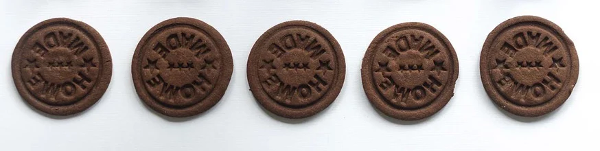 A row of chocolate biscuits with Home Made stamped on them. 