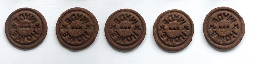 A row of chocolate biscuits with Home Made stamped on them.