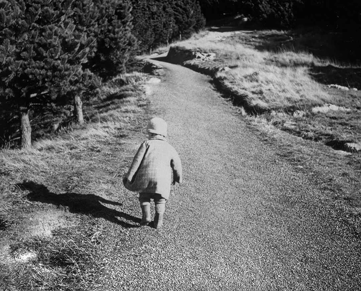 Child walking up a gravel road. 