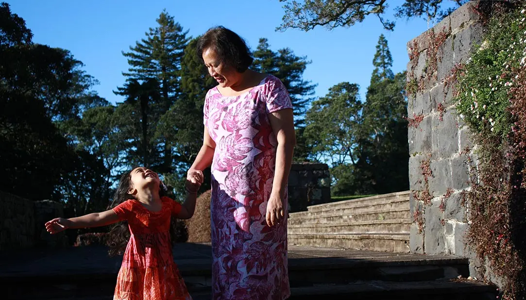 Photo of Pacific peoples — showing a grandmother and her mokopuna holding hands.