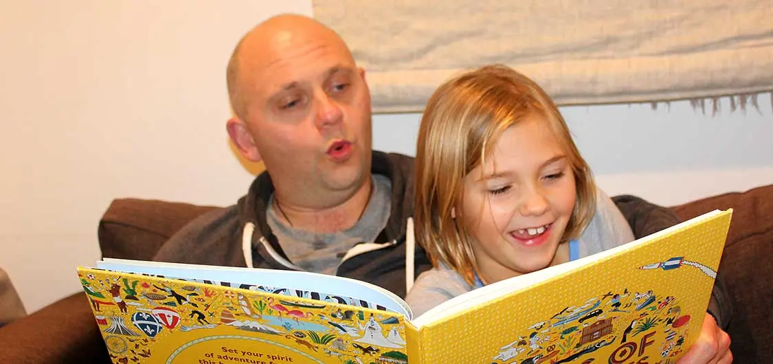 Father and daughter reading at home.