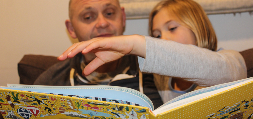 Father and daughter reading at home.