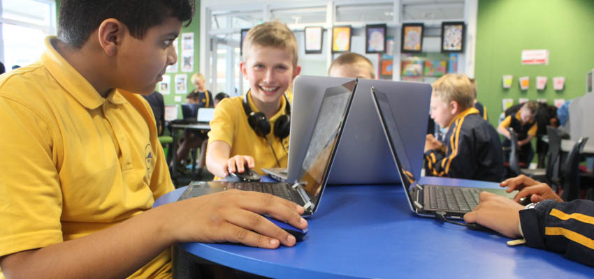 Students working on laptops in the classroom