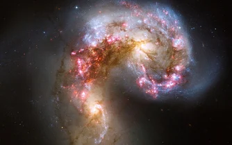 Antennae Galaxies in space.  These two spiral galaxies started to interact a few hundred million years ago.