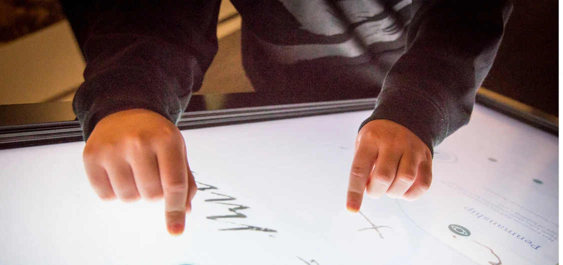 Child's hand touching an interactive exhibit at He Tohu in Wellington.