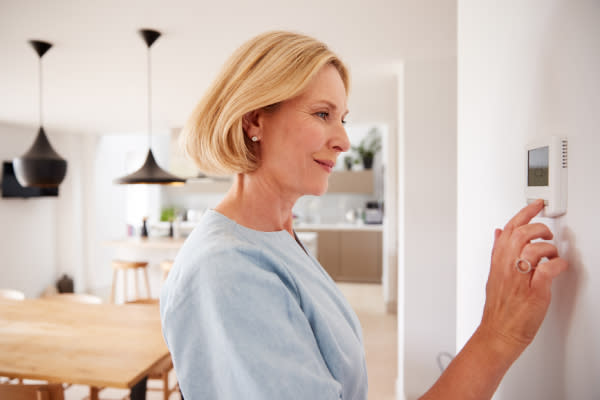 Woman adjusting heating in home