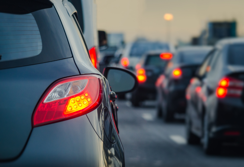 Several cars lined up in queue of traffic. 