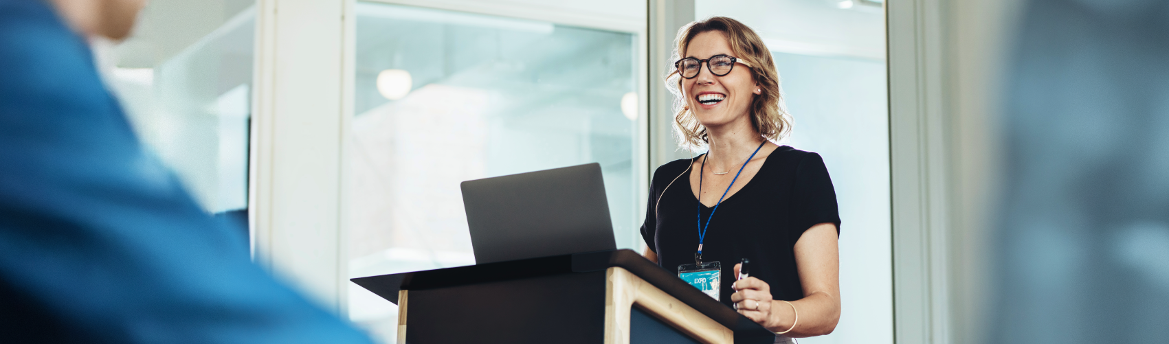 A lady stood at an open laptop, smiling