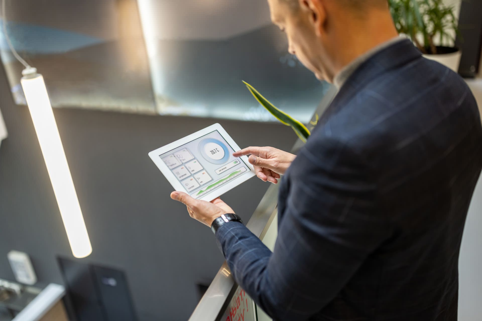 Person looking at small tablet with range of graphs and data on it