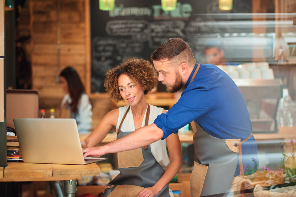 Workers in a coffee shop on laptop