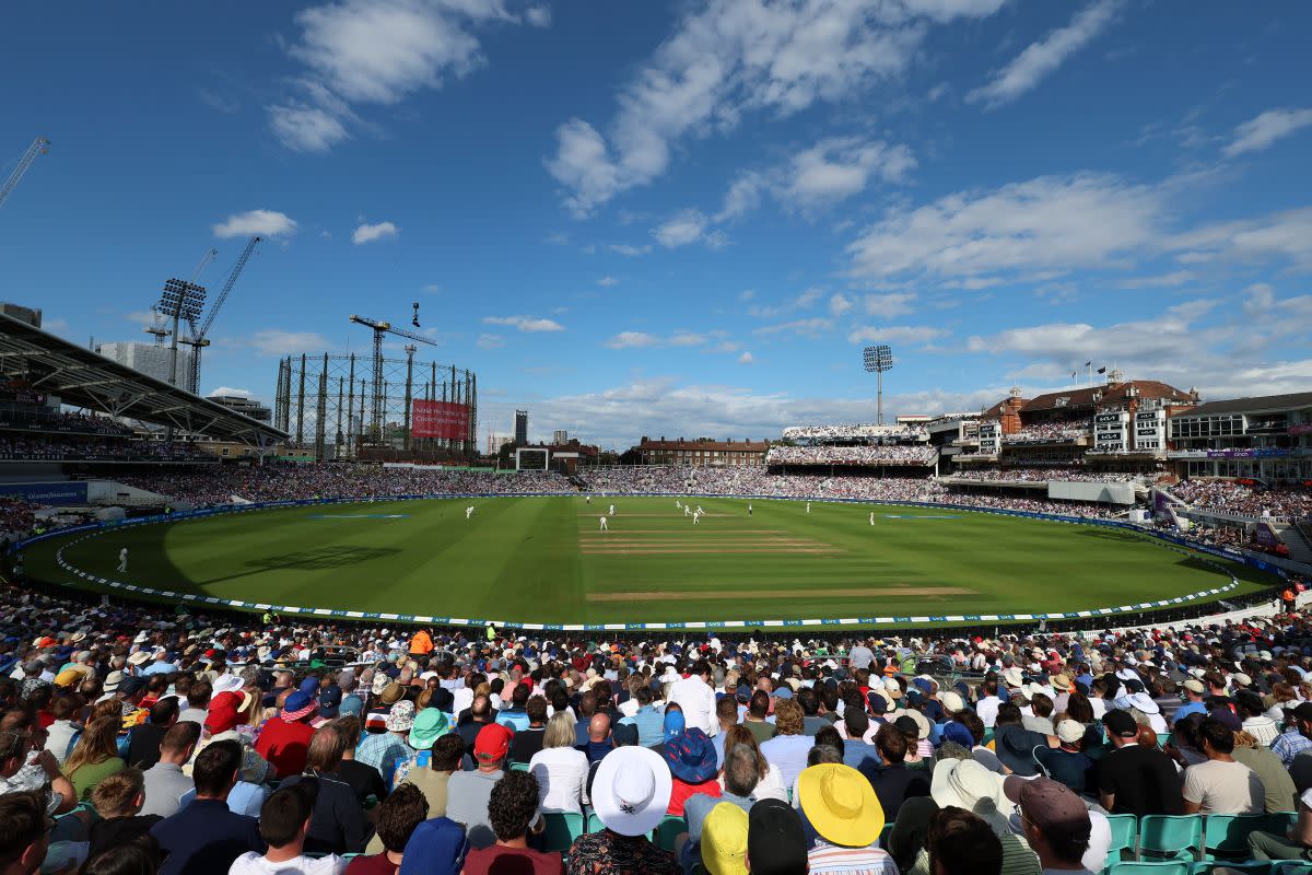 A wide view from a stand at the Kia Oval cricket ground, with a sunny blue sky in the background