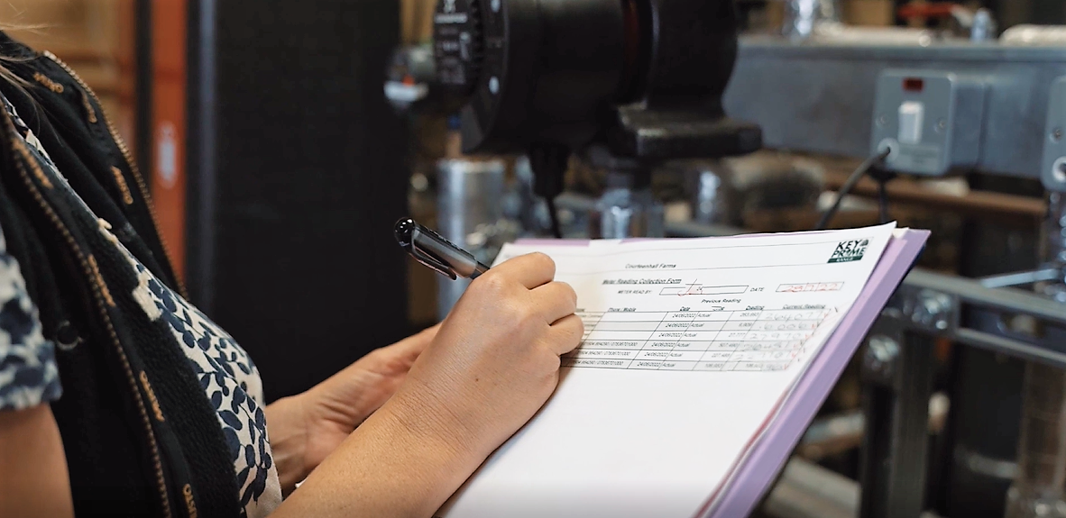 Person holding clipboard and pen