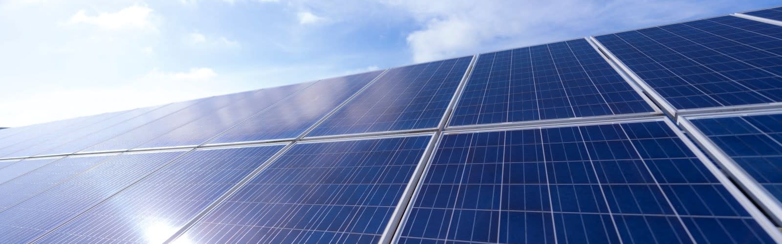 Solar panels angled, with the sky in the background
