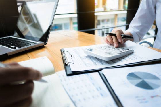 Officer worker sitting at desk using calculator