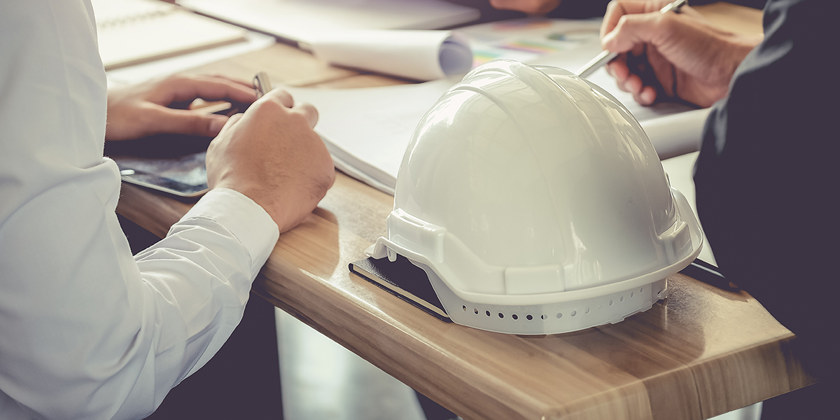 Two people having a a business meeting on a construction site office. 