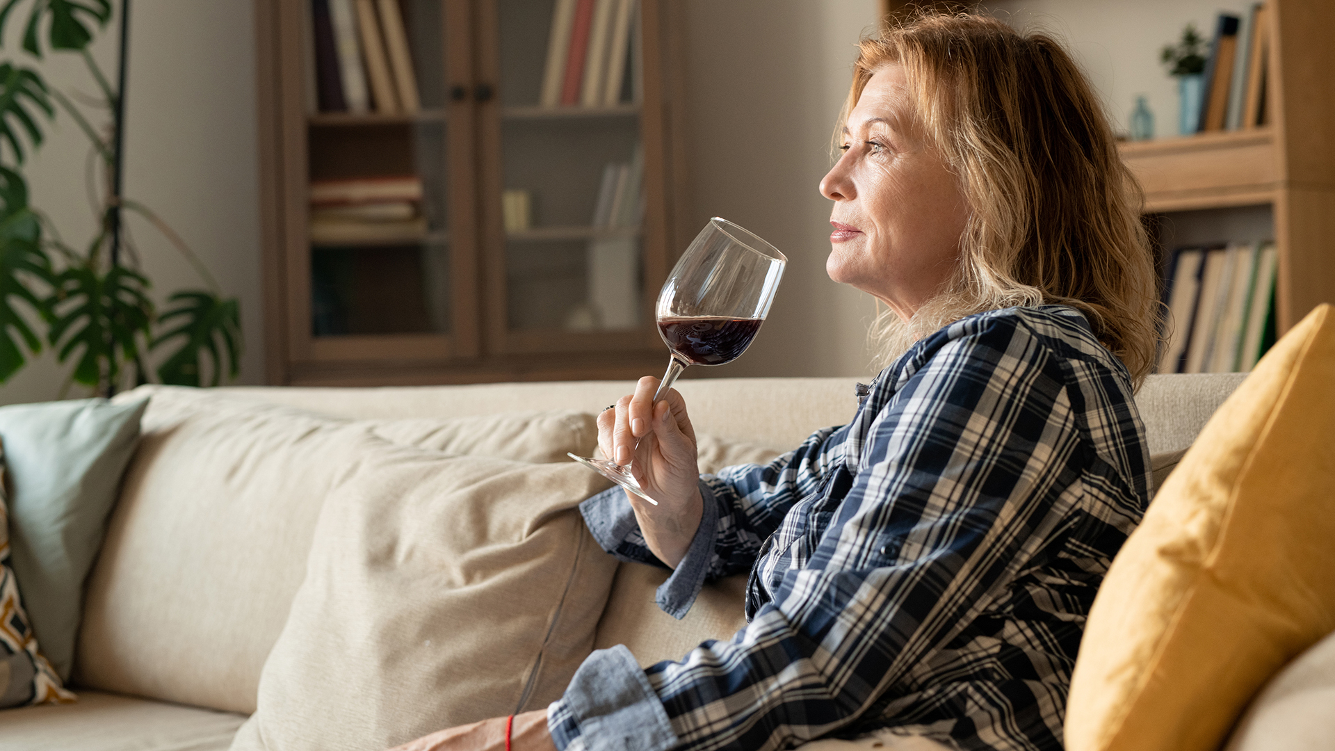 Woman on couch drinking red wine
