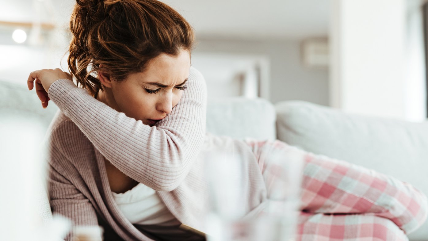 Woman sick and coughing on the couch