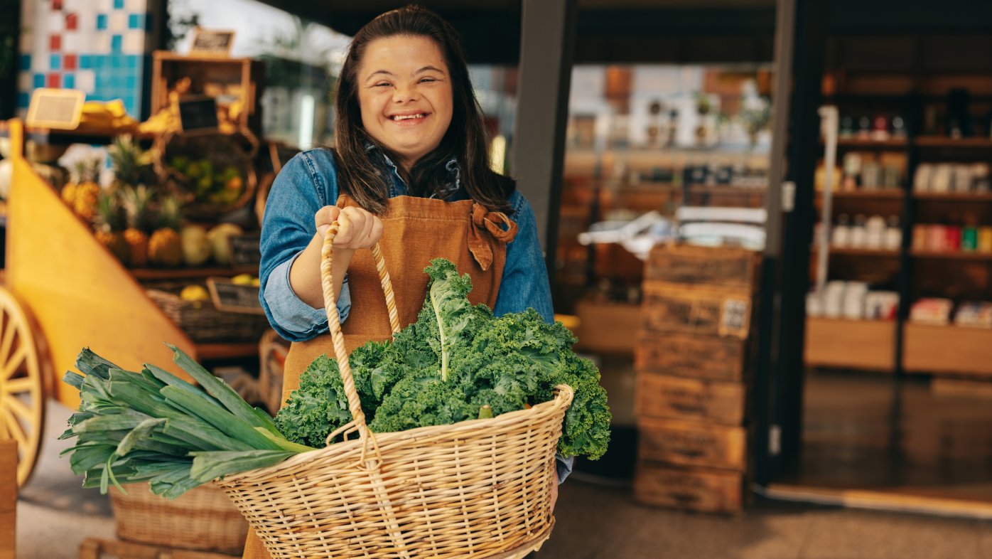 Woman holding basket with green vegetables