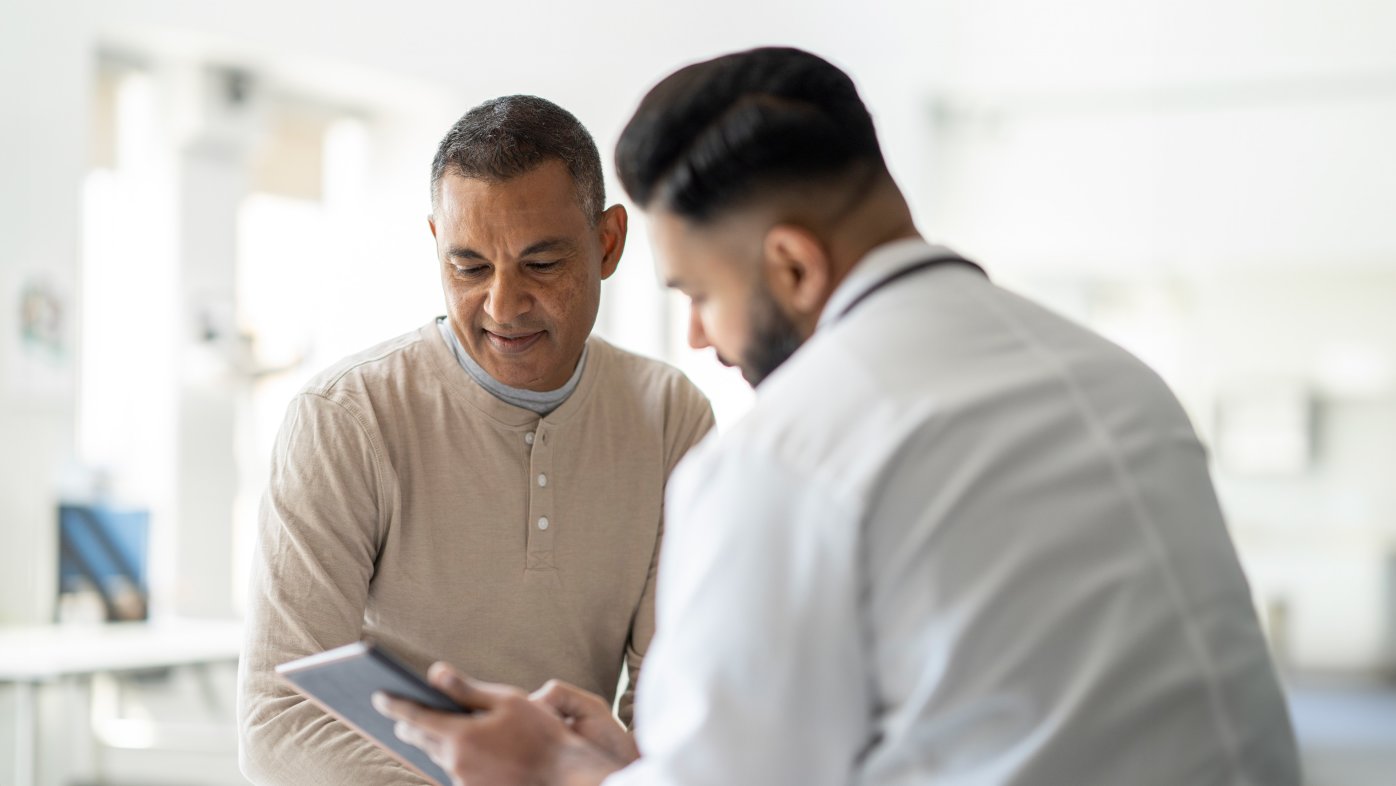 Male patient reviewing test results with doctor.
