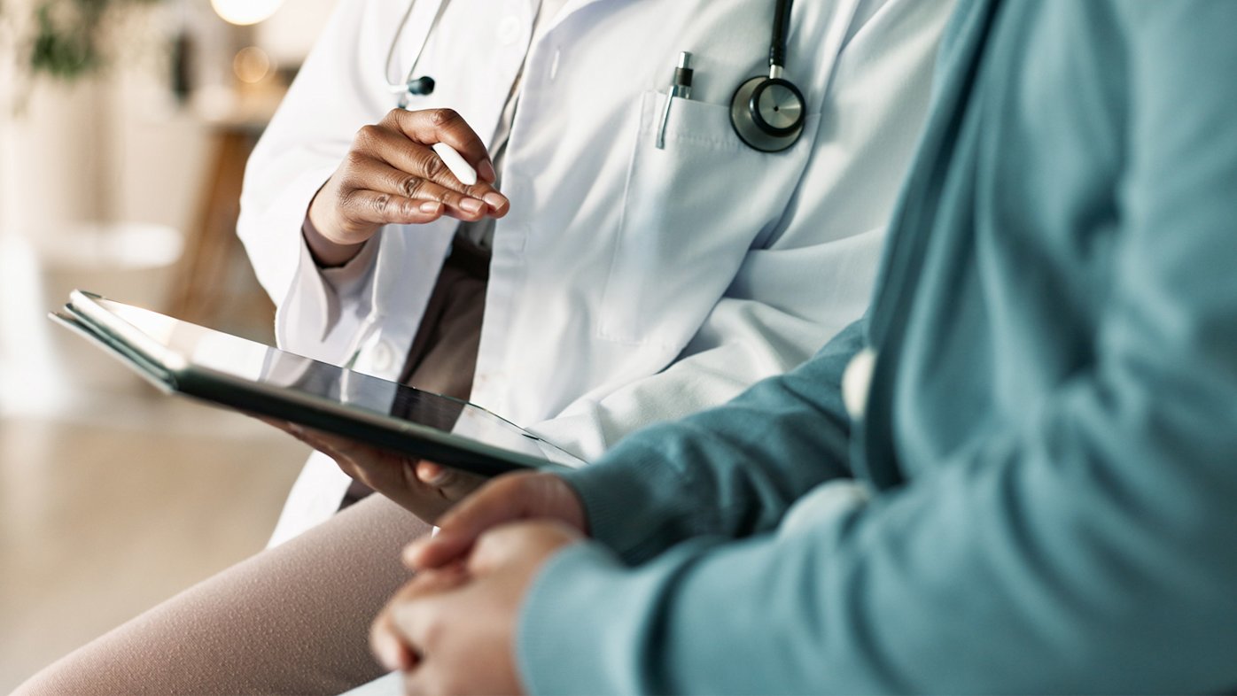 Doctor sitting with patient with stethoscope and tablet
