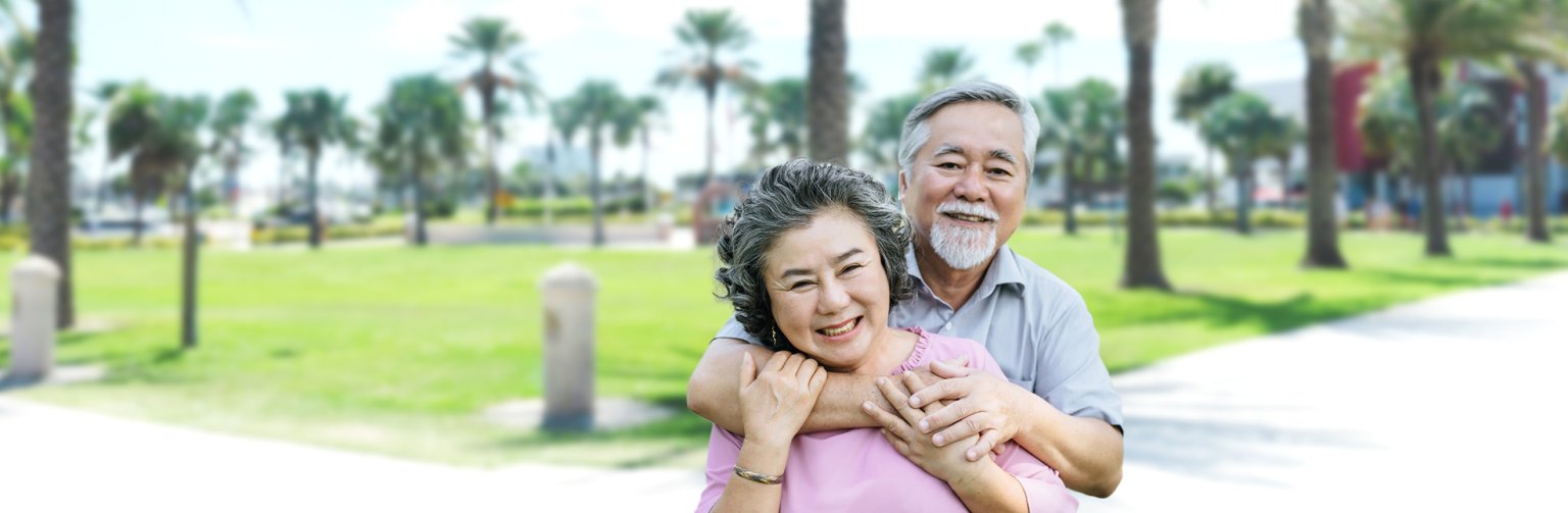A senior couple with a park in the background