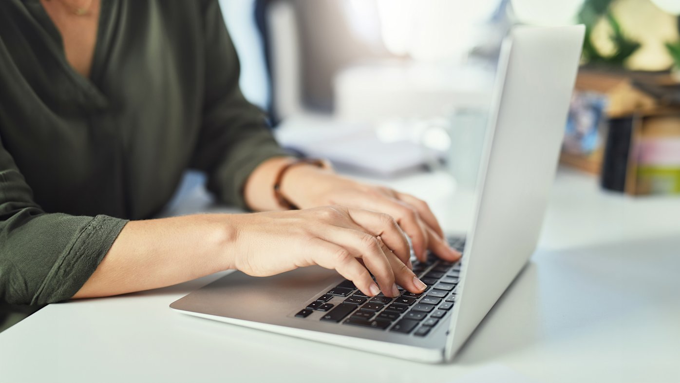 Woman typing on laptop.