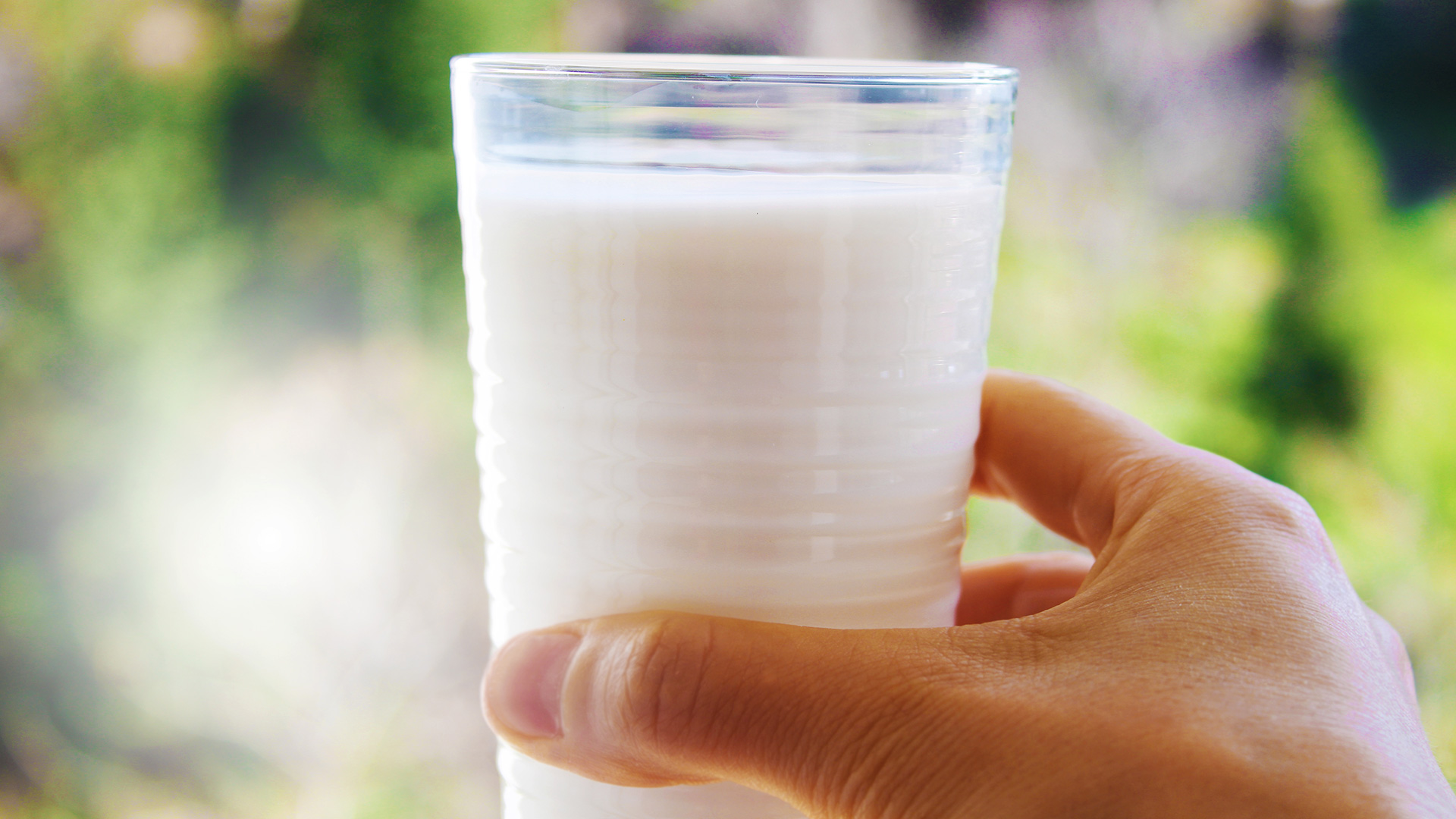 Person holding a glass of milk
