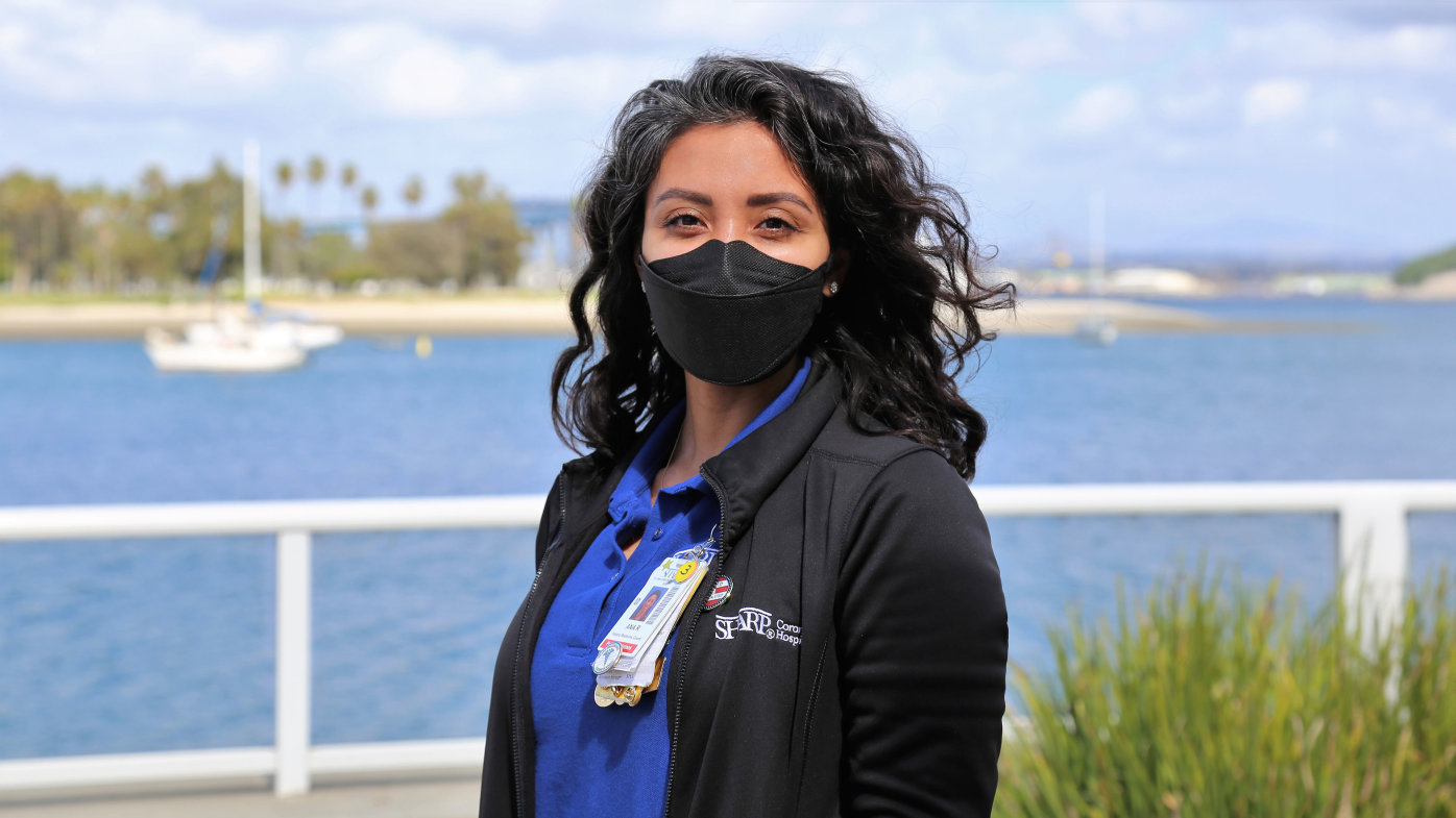 Patient relations coordinator from Sharp wearing a mask standing by the bay. 