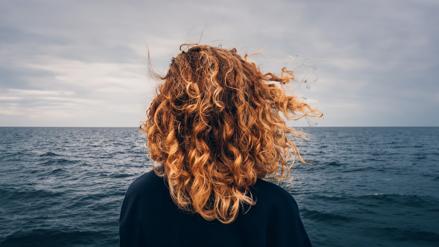 Person looking at a cloudy sky over an ocean