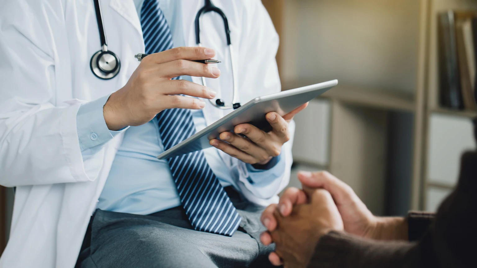 Doctor with tablet consulting with patient