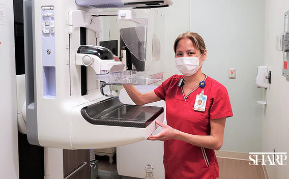 Sharp Rees-Stealy nurse standing next to a 3D mammogram unit.