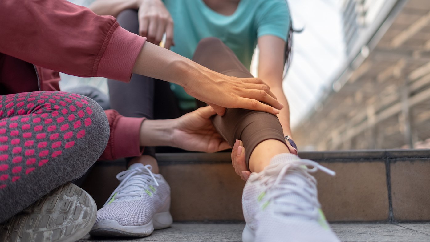 Injured athlete being assisted with sprained ankle