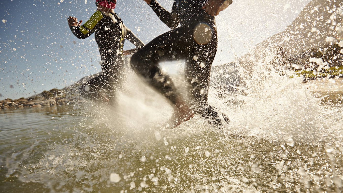 Surfers in wetsuits splashing in the waves of the ocean