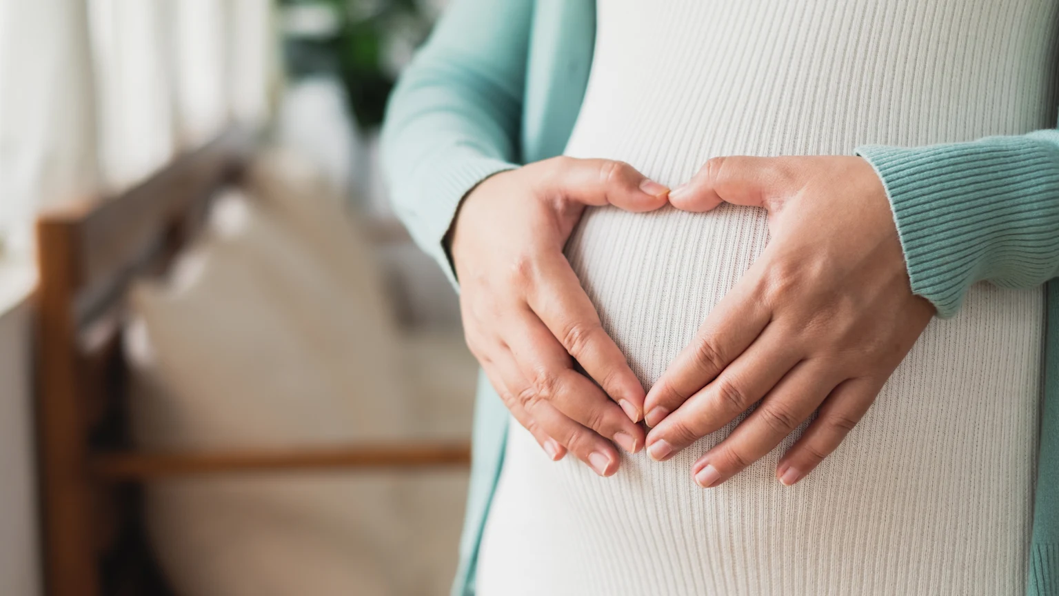 Pregnant woman holding her hands over her belly