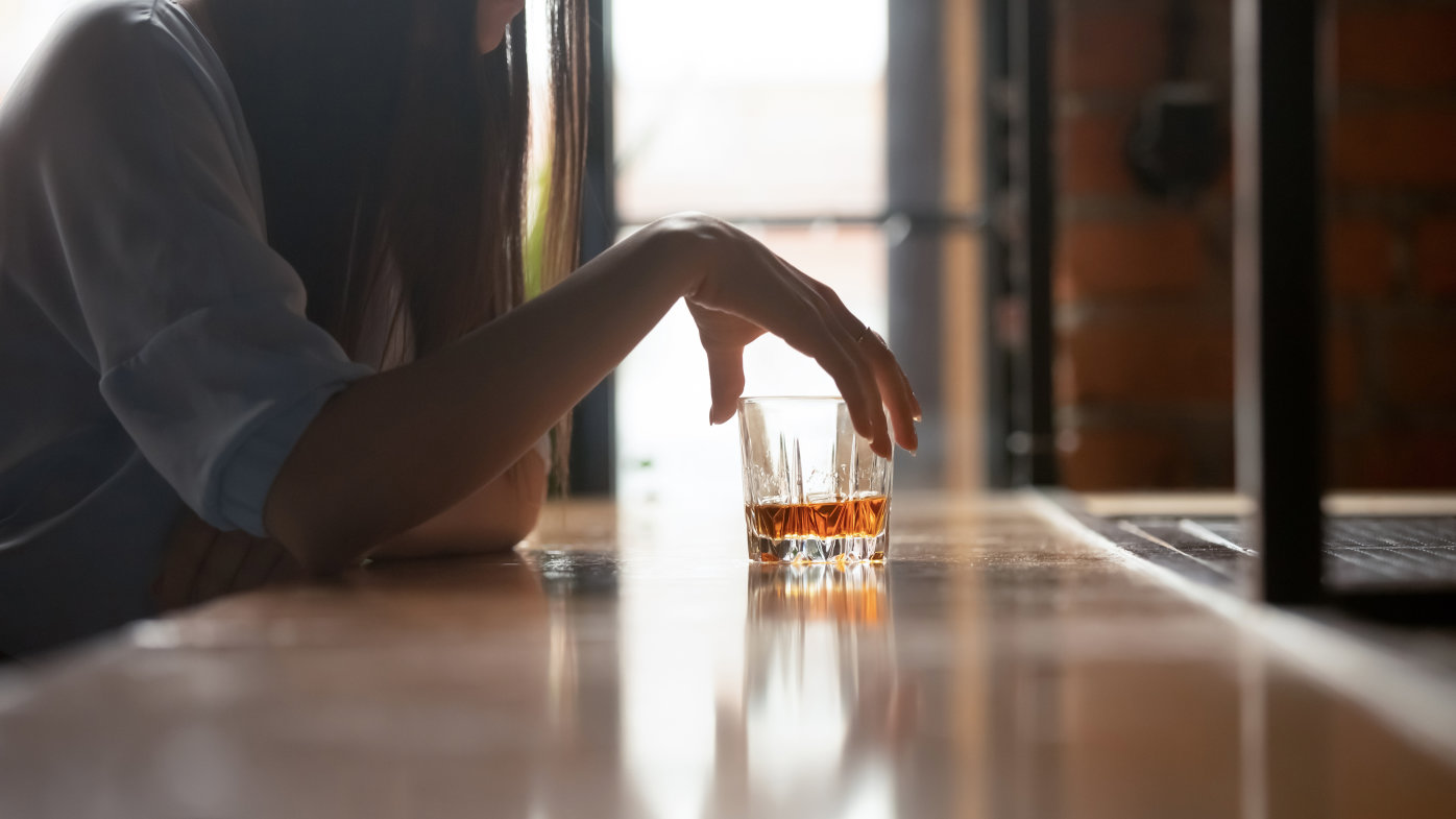 Woman drinking whiskey at a bar