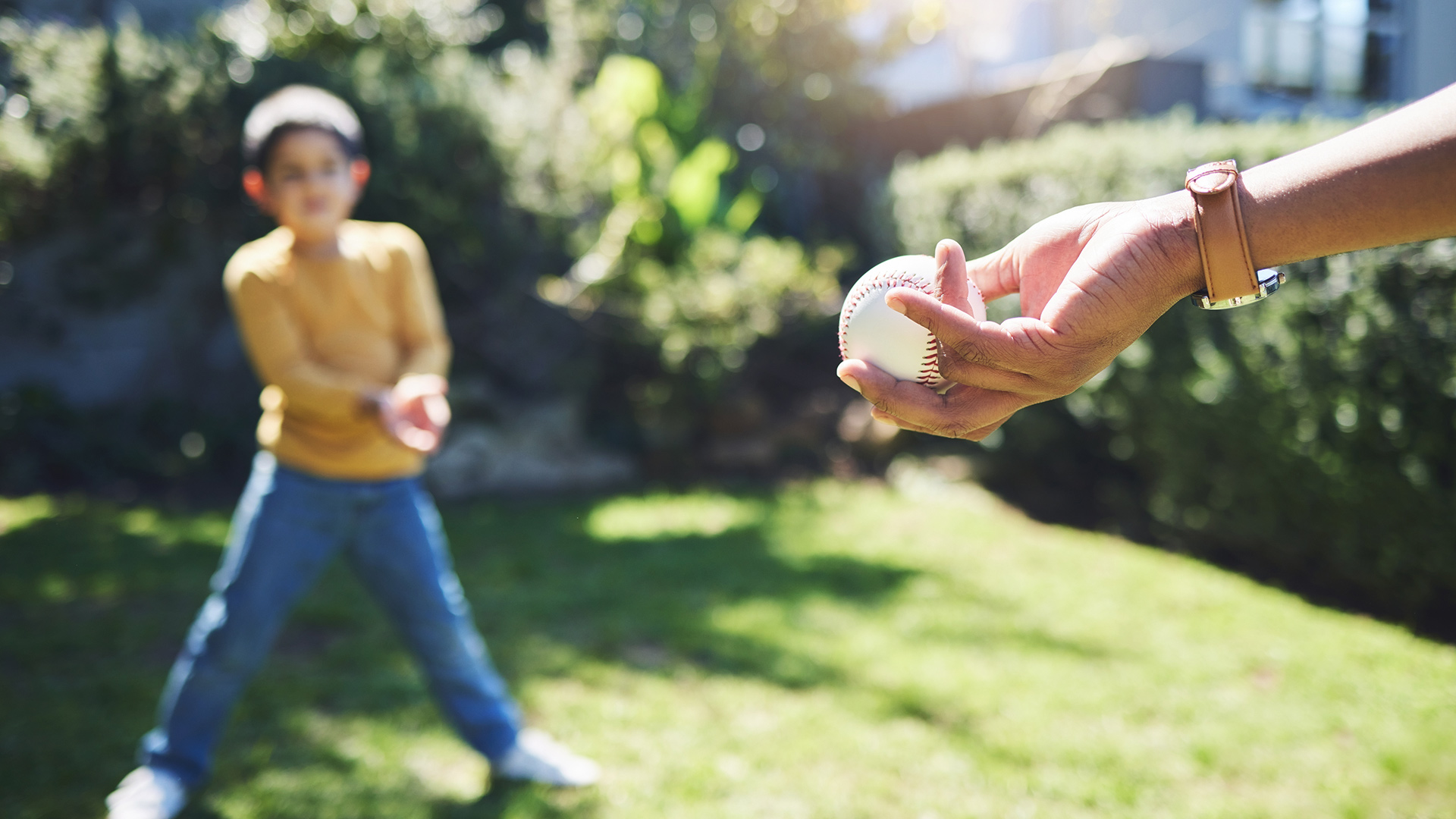 Mom throwing baseball to her son
