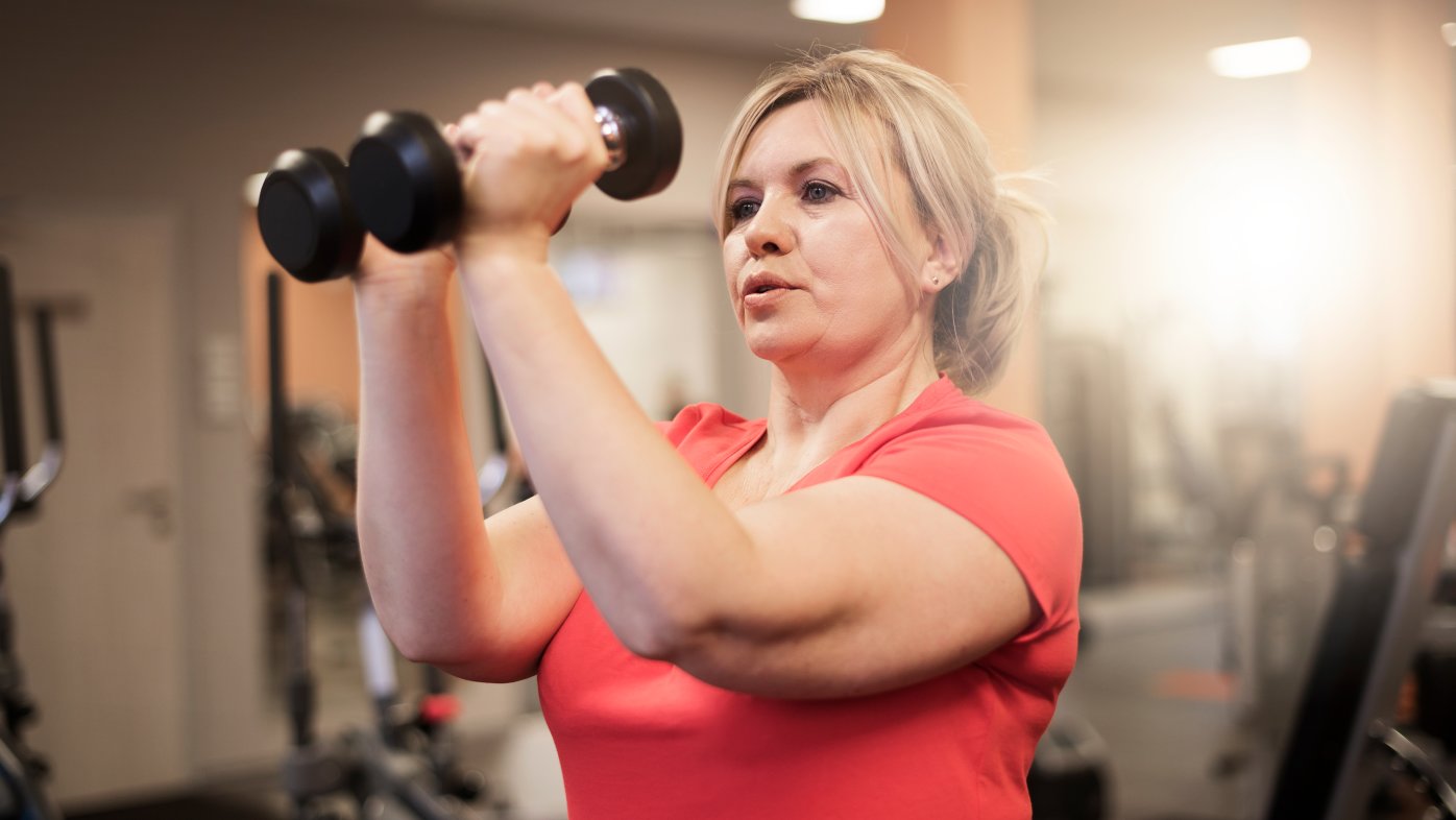 Woman using weights to exercise in the gym