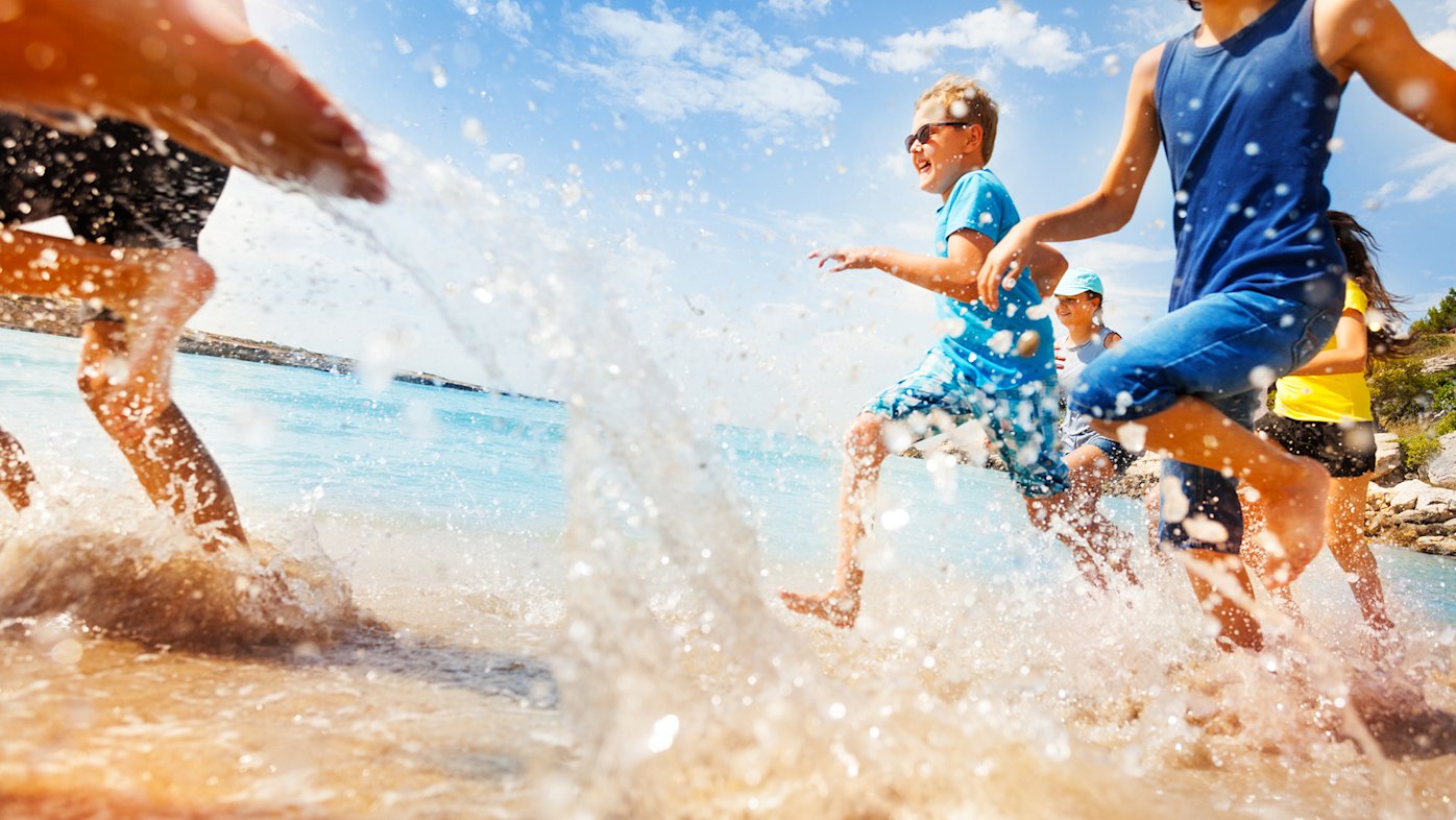 Kids running through the water at the beach