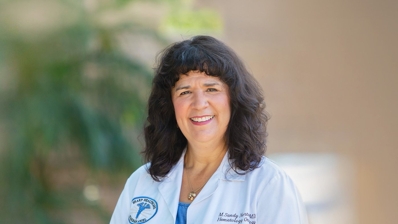 Female doctor in front of wall and tree