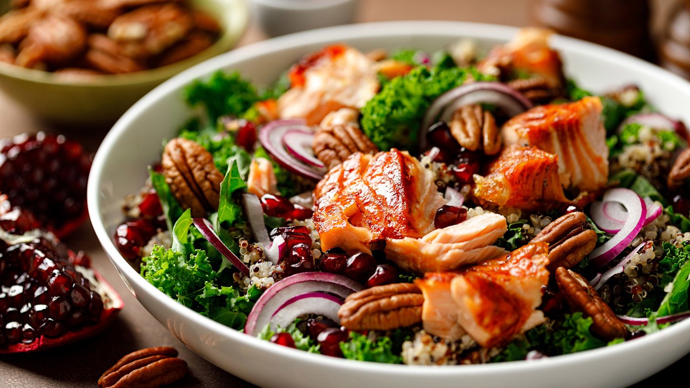 Kale salad with red onions, salmon and walnuts