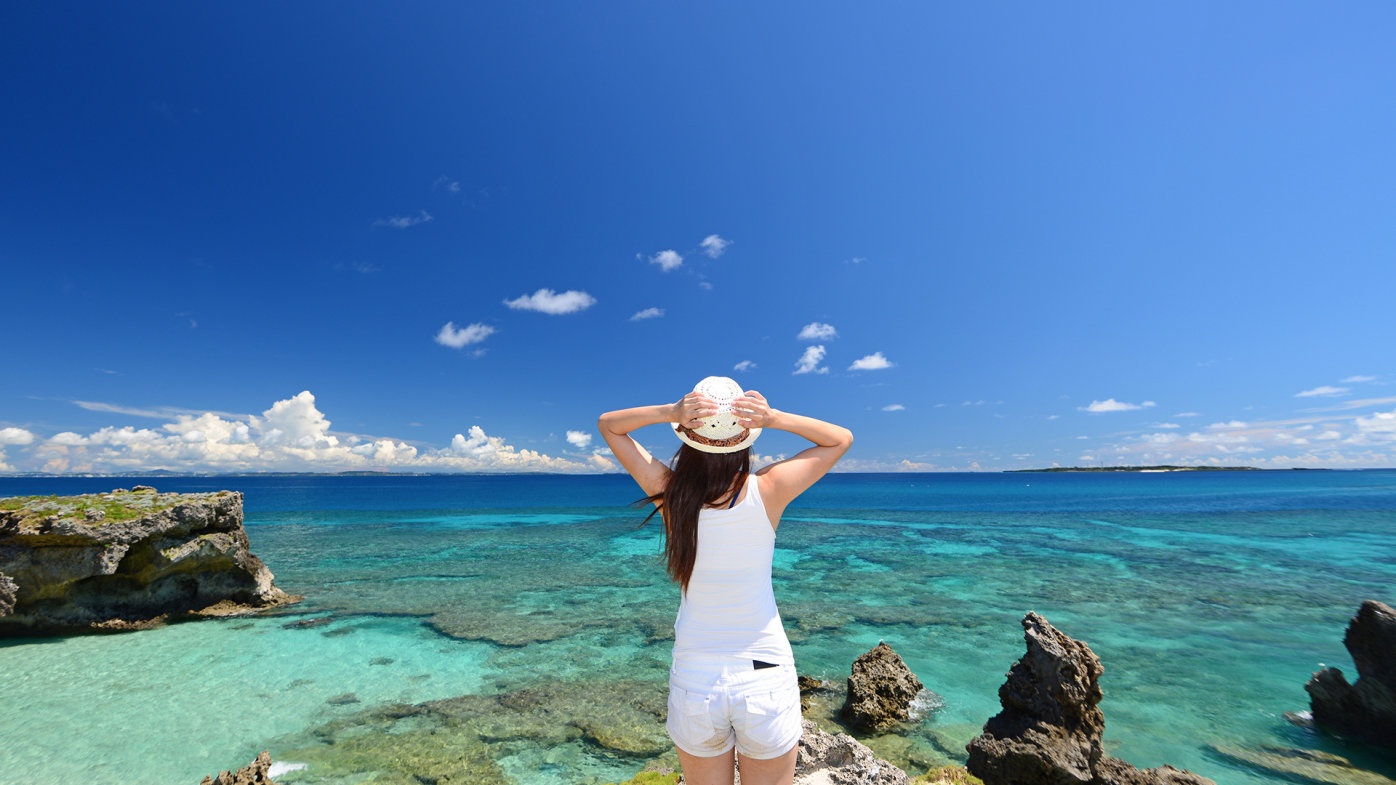 Woman wearing hat overlooking ocean scene