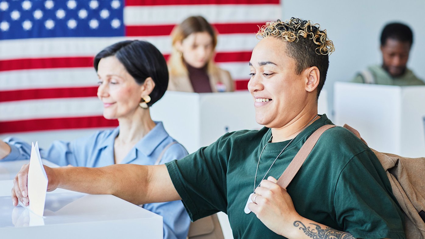 People voting with American flag behind them
