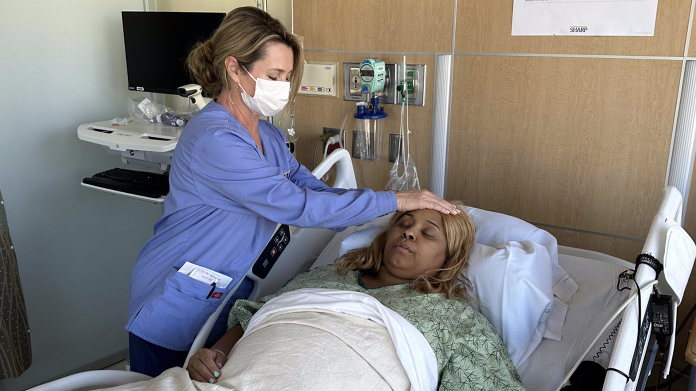 Melanie Adams, a reiki practitioner, treats Dannica Robinson, a Sharp HealthCare patient